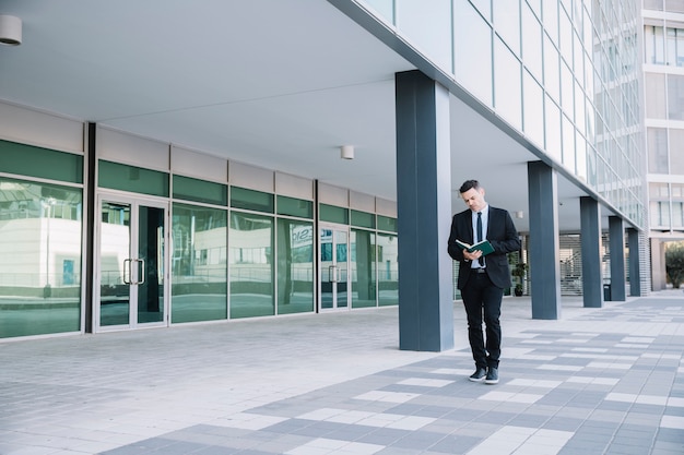 Businessman walking and reading