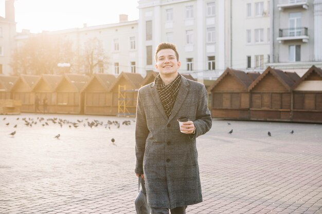 Free photo businessman walking with coffee