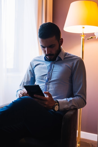 Businessman watching tablet in chair