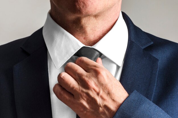 Businessman wearing tie, getting ready to work