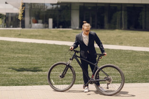 Businessman with bicycle in a summer city