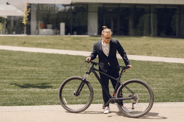 夏の街で自転車を持ったビジネスマン