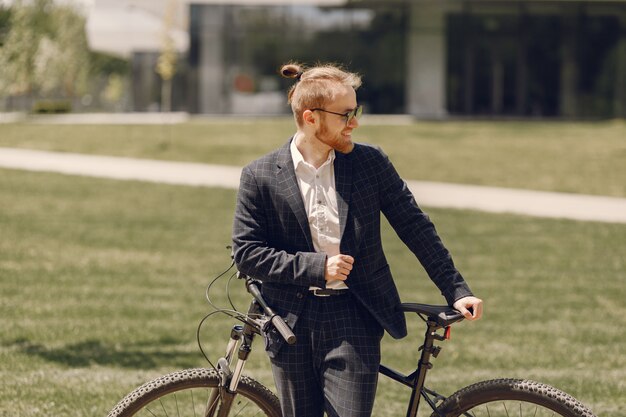 Бизнесмен с велосипедом в летнем городе