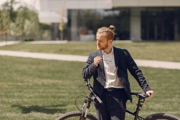 Businessman with bicycle in a summer city