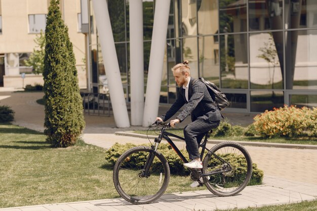 Businessman with bicycle in a summer city