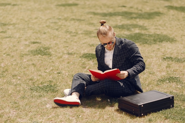 Businessman with book sitting in a summer city