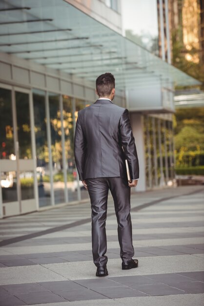 Businessman with a diary walking in the office campus