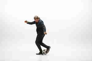 Free photo businessman with football ball in office. soccer freestyle. concept of balance and agility in business.