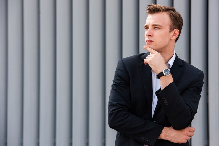 Free Photo businessman with hand on chin looking away