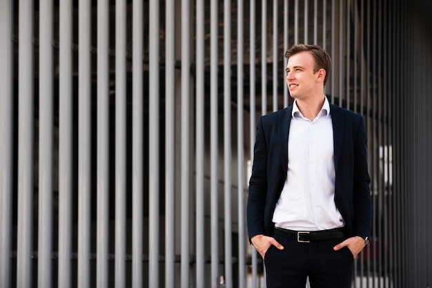 Businessman with hands in pockets looking away