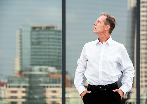 Businessman with hands in pockets looking away