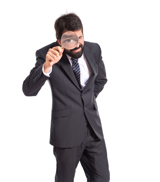 Businessman with magnifying glass over white background