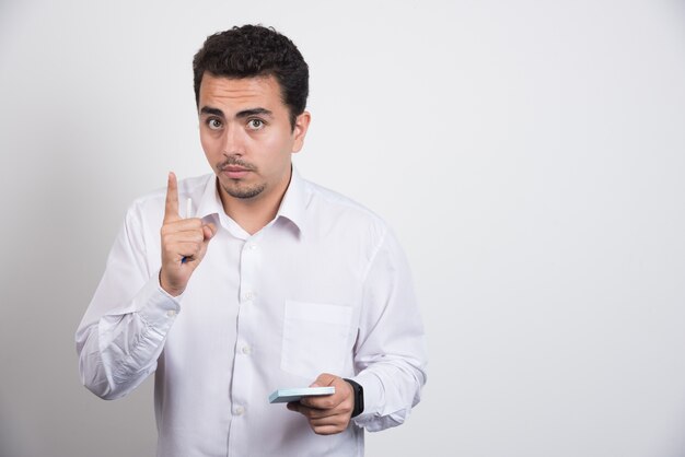 Businessman with memo pads wants a minute on white background.