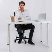 Foto gratuita uomo d'affari con il telefono in ufficio