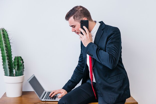 Businessman with smartphone and laptop