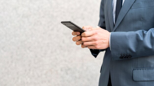 Businessman with smartphone outdoors