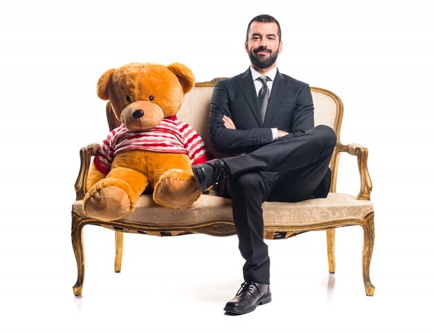 Businessman with teddy sitting on vintage armchair