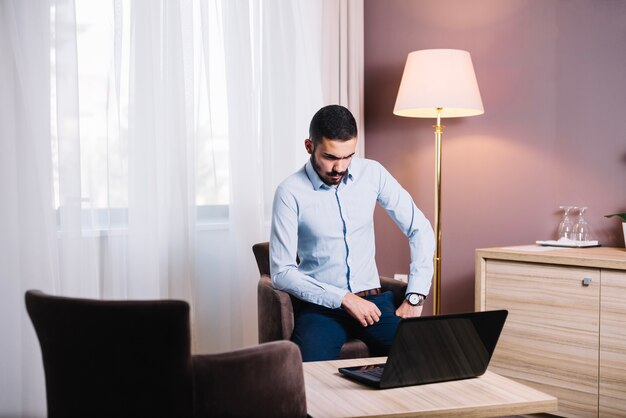 Foto gratuita uomo d'affari che lavora al computer portatile