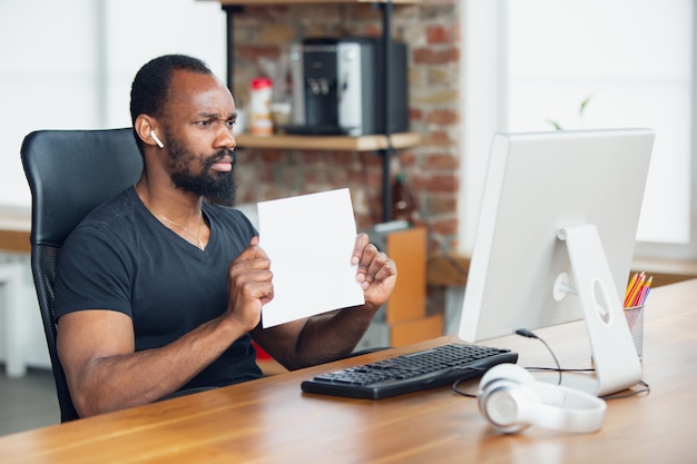 Businessman working in office and holding blank placard