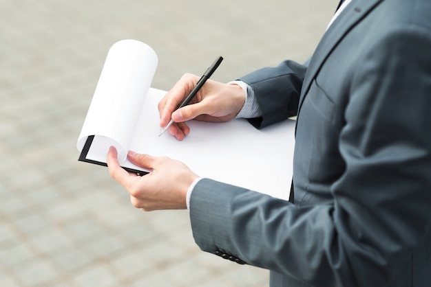 Businessman writing on clipboard