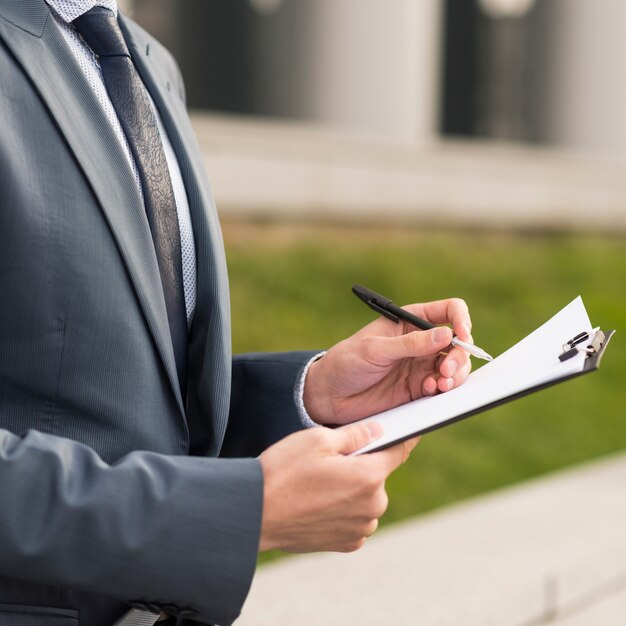 Businessman writing on clipboard