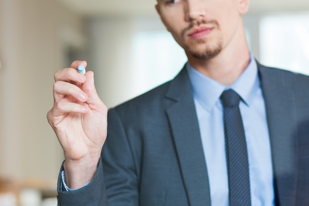 Businessman Writing on Glass Board with Marker