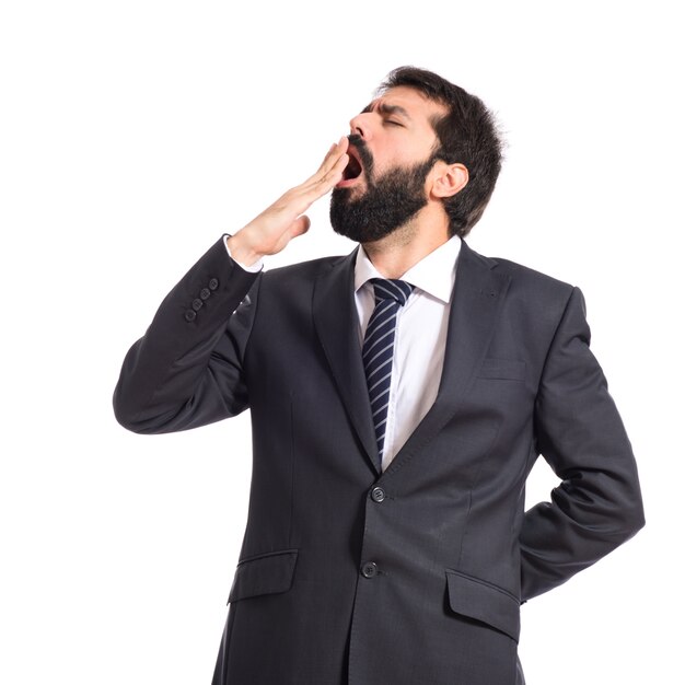 Businessman yawning over isolated white background