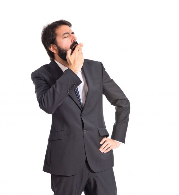 Businessman yawning over isolated white background