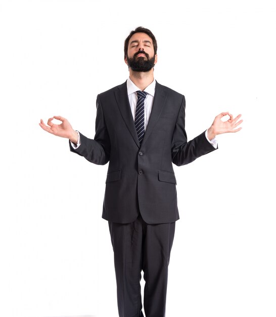 Businessman in zen position over white background