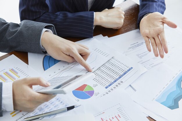 Businessmen in elegant suits at a business meeting making calculations in the office