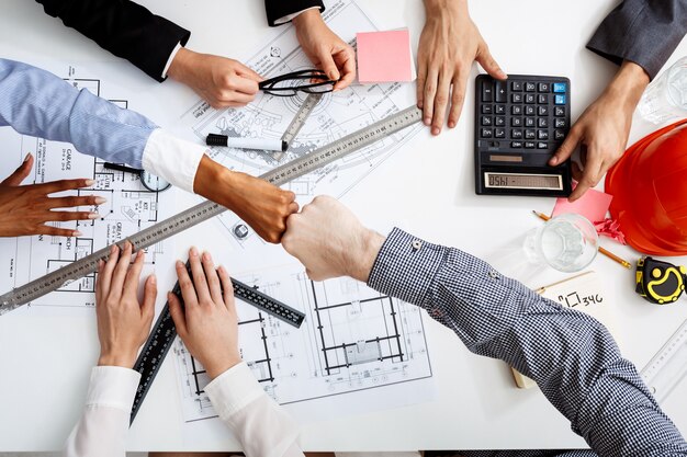  businessmen hands on white table with documents and drafts