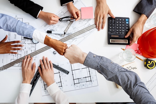  businessmen hands on white table with documents and drafts