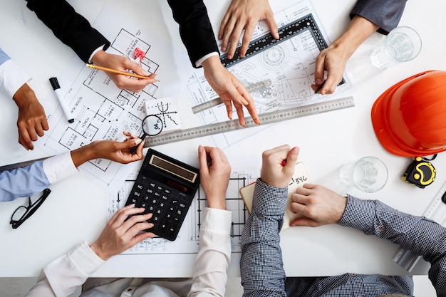  businessmen hands on white table with documents and drafts