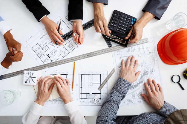  businessmen hands on white table with documents and drafts