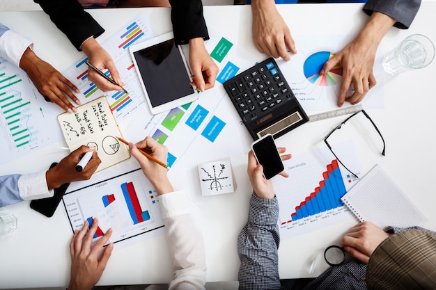  businessmen hands on white table with documents and drafts