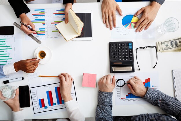  businessmen hands on white table with documents and drafts