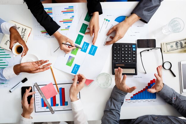  businessmen hands on white table with documents and drafts