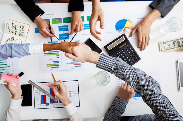  businessmen hands on white table with documents and drafts