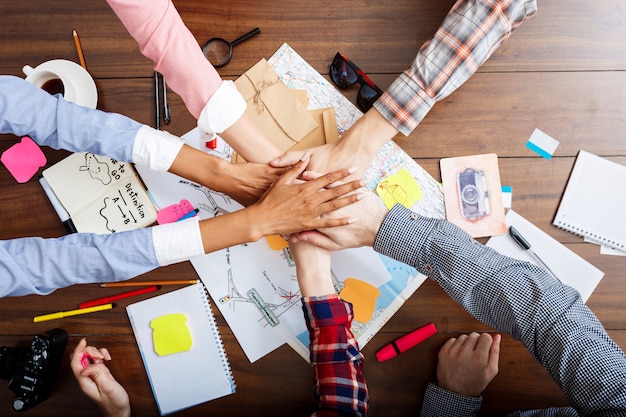  businessmen hands on wooden table with documents and drafts