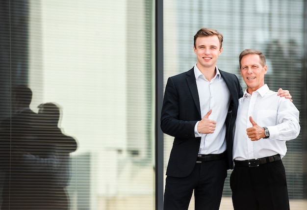 Free photo businessmen thumbs up looking at camera