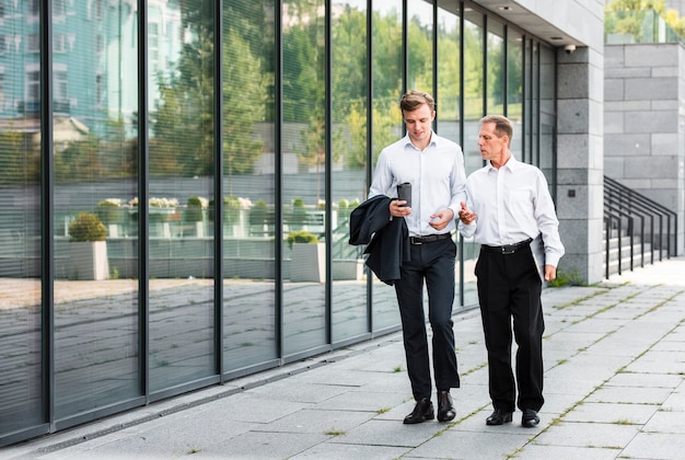 Businessmen walking near building