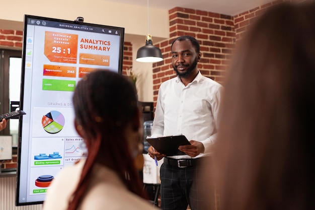 Businesspeople analyzing financial graph working at business presentation during startup company office. Diverse entrepreneurs brainstorming ideas for management project discussing partnership