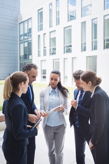 Foto gratuita persone di affari che discutono sopra la compressa digitale