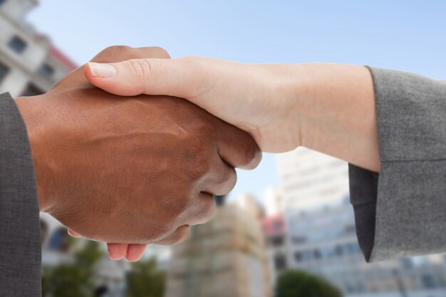 Free photo businesspeople giving a firm handshake