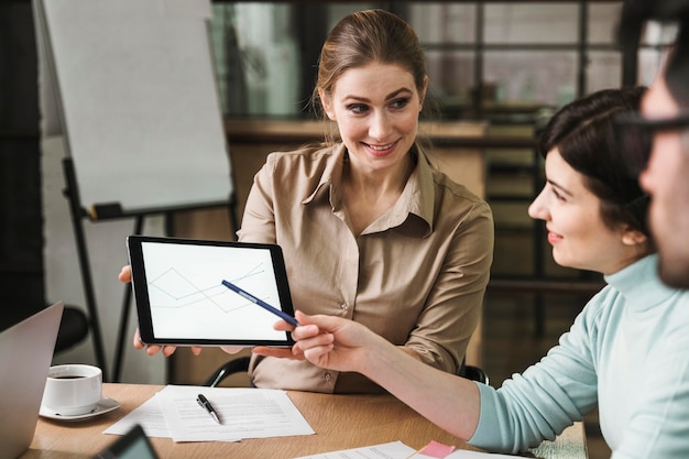 Businesspeople having a meeting indoors and using tablet