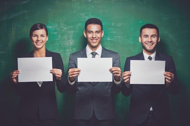 Free photo businesspeople holding blank sheets of paper