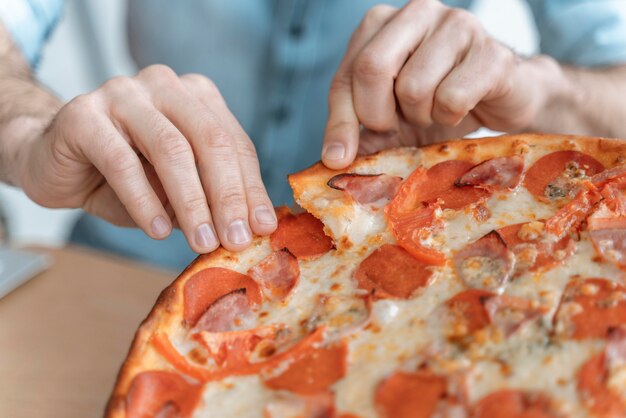 Бизнесмены на обеденном перерыве едят пиццу крупным планом