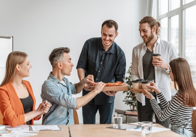 Businesspeople on lunch break eating pizza