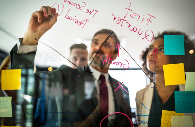 Free photo businesspeople planning on a glass wall