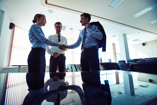 Businesspeople shaking hands at workplace